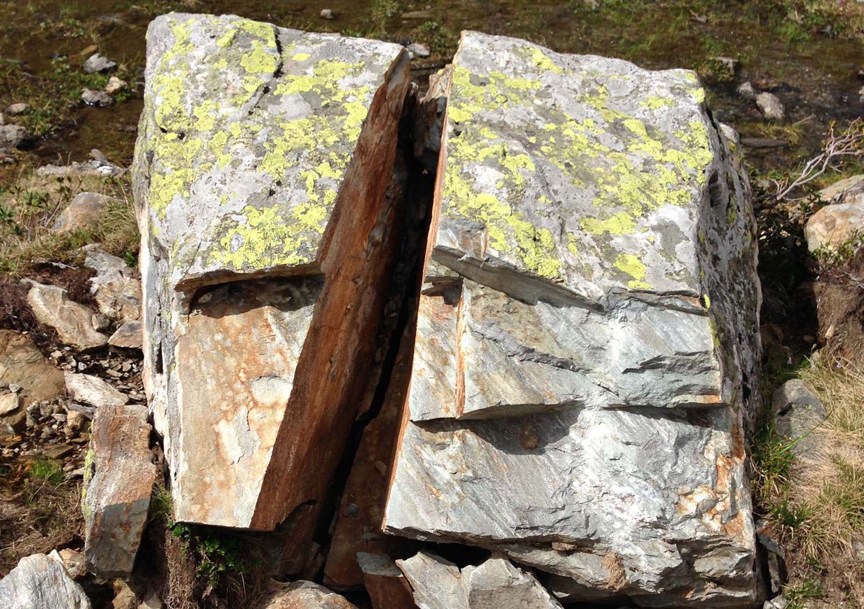 Photo of a stone that is broken in the middle. The fracture looks like a cross.